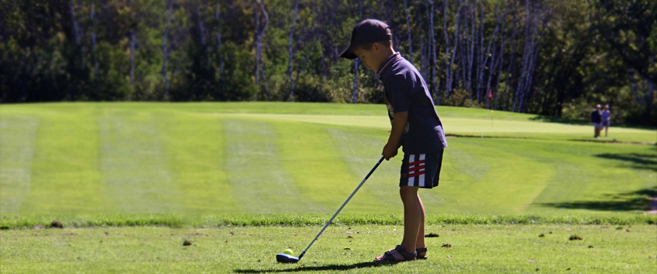 junior golfer teeing off